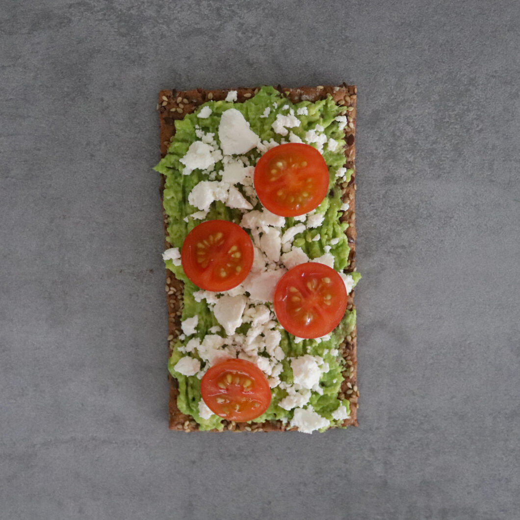 Crackers met avocado, feta en cherry tomaten