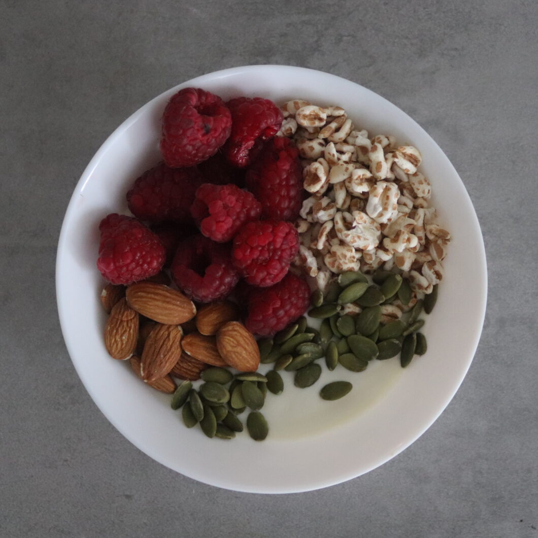 Kokos yoghurt met frambozen, gepofte spelt en ongezouten amandelen